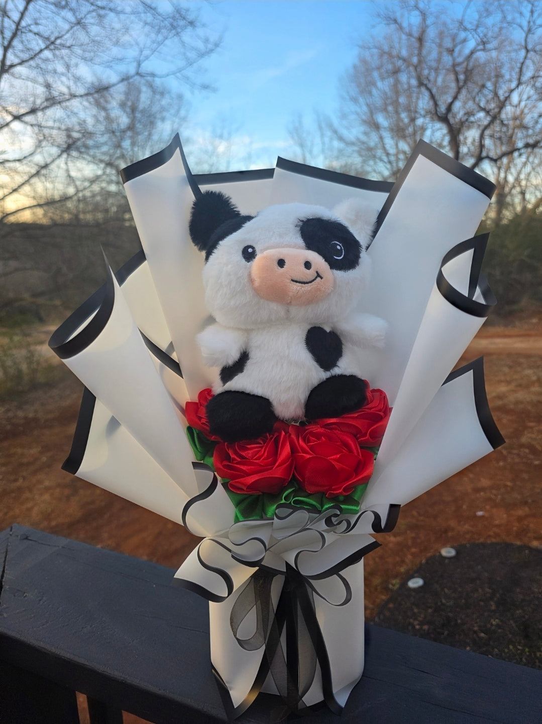 Black and white cow with red eternal roses